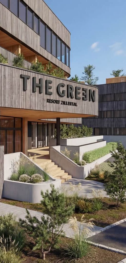 Eingangsbereich eines modernen Gebäudes mit Holzfassade und dem Schriftzug 'THE GREEN'