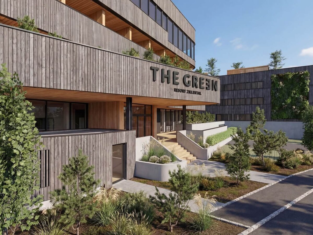 Eingangsbereich eines modernen Gebäudes mit Holzfassade und dem Schriftzug 'THE GREEN'