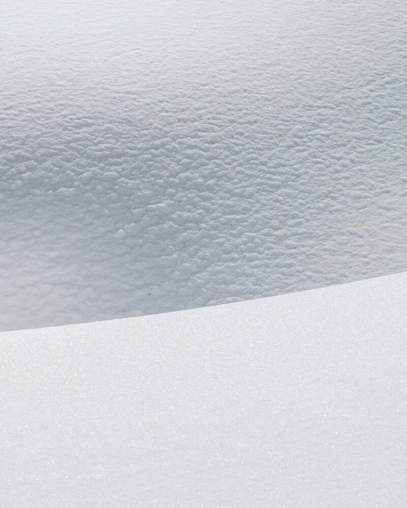Nahaufnahme von unberührtem Schnee mit glatter und leicht strukturierter Oberfläche