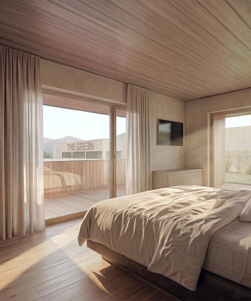 Schlafzimmer mit großem Bett, Holzwänden und -boden, Zugang zu Balkon mit Sitzmöbeln