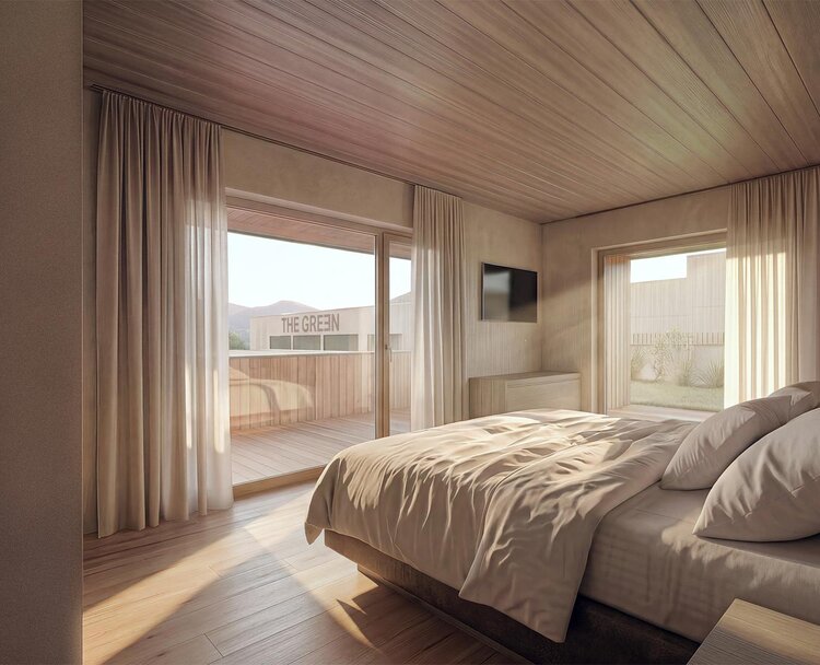 thegreen-zimmer-haupthaus-1 Schlafzimmer mit großem Bett, Holzwänden und -boden, Zugang zu Balkon mit Sitzmöbeln
