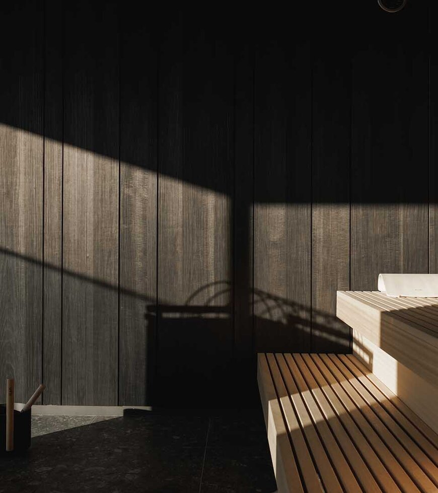 Innenraum einer Sauna mit Holzbänken und Holzwänden, beleuchtet durch Sonnenlicht mit Schattenwurf